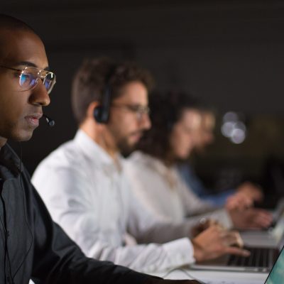 Concentrated African American call center operator working. Thoughtful call center operators during working process. Call center concept
